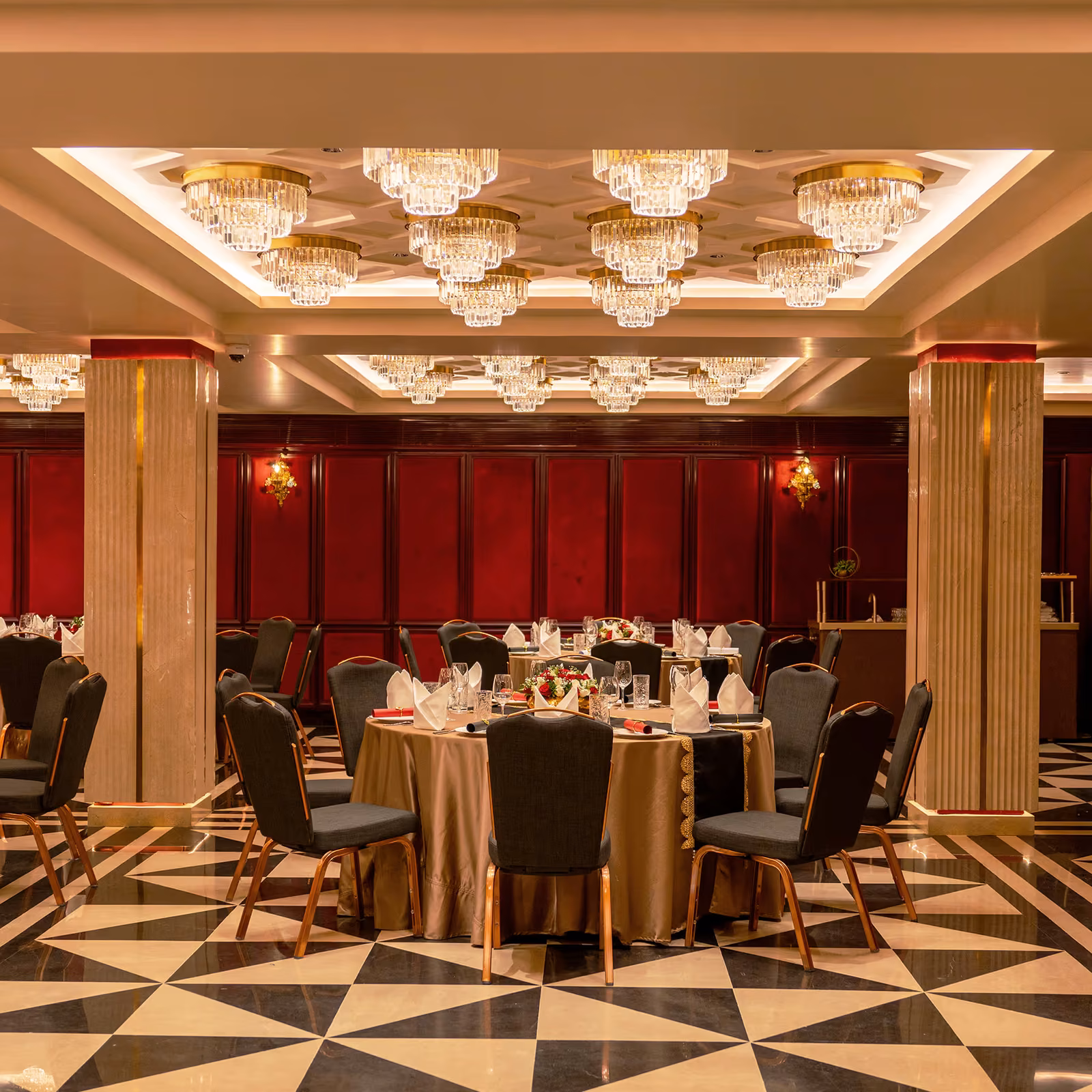 Burgundy Banquets interior with crystal chandeliers, red panelled walls and checkerboard marble floor
